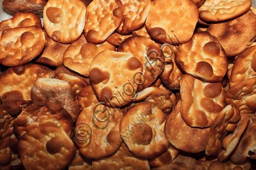 Photograph of traditional Ligurian 'gallette del marinaio' sailor hardtack on a wooden board, a typical gastronomic product
