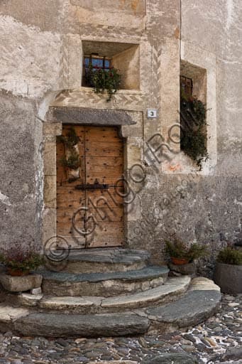 Antique solid wood door with original brass hardware, detail of a historic house entrance