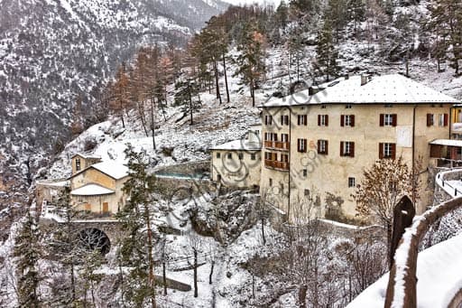 Exterior view of the historic stone buildings of the Bagni Vecchi Thermal Baths in Bormio, set in the Alpine landscape