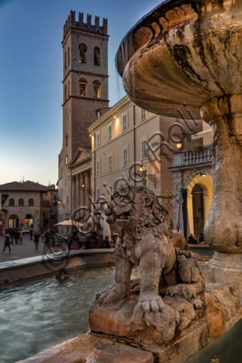 Assisi, night view of Piazza del Comune with lighting. Detail of the Three Lions Fountain in foreground and Palazzo del Capitano del Popolo in background.
