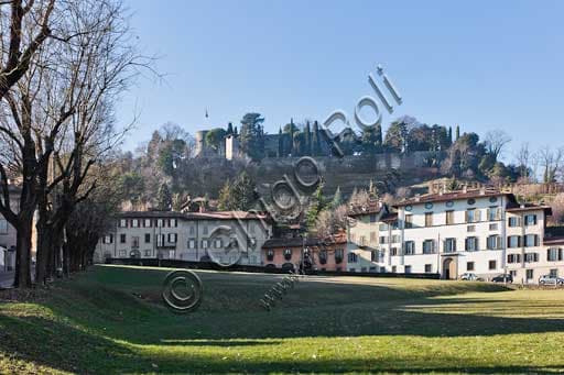 Panoramic view of historic houses on Fara Street, Bergamo's Città Alta, with the former Convent of St. Augustine and the Stronghold of Bergamo in the background.