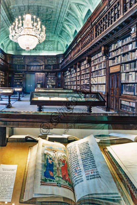 Sala Maria Teresa Biblioteca Braidense Milano con codice miniato illuminato in primo piano