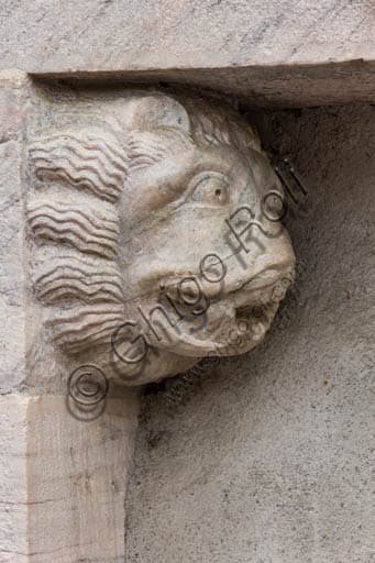 Close-up of a carved marble lion head on a side portal of the Church of Saints Gervasio and Protasio in Bormio, Lombardy.