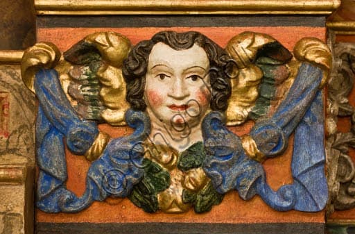 Detail of the carved wooden cornice in the side chapel of the Collegiate Church of Saints Gervasio and Protasio in Bormio, example of sacred wood carving art.