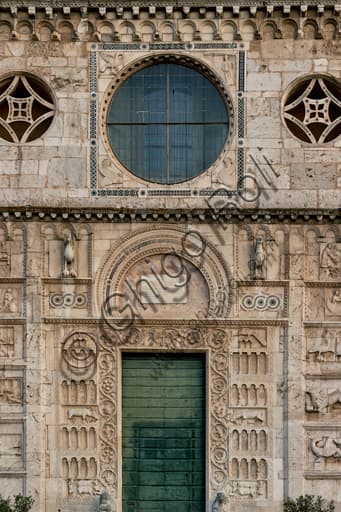 Detail of the Romanesque façade of St. Peter's Church Spoleto: central oculus with Cosmatesque decoration and evangelist symbols, main portal