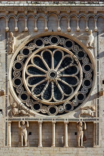 Detail upper part Spoleto Cathedral facade with rose window, Evangelist symbols and blind gallery