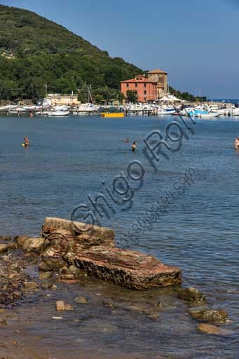 Photograph of the Etruscan furnaces on the beach of the Baratti Gulf with the small port in the background