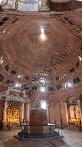 Interior of the Cremona Baptistery showing bare brick walls and the baptismal font in red Verona marble