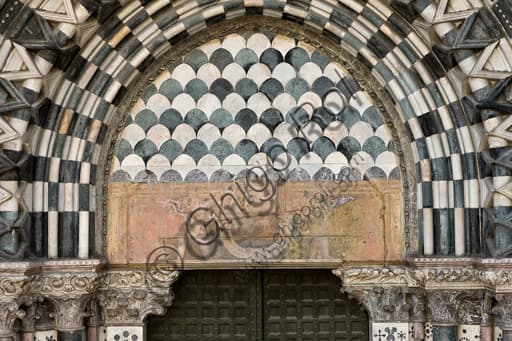Lunette and architrave with cartouche between shield-bearing angels, right doorway west facade St. Lawrence Cathedral Genoa