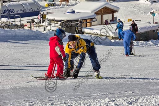 Gallo Cedrone ski instructor teaching a child during a private ski lesson on the Bormio 2000 ski slopes, Italy