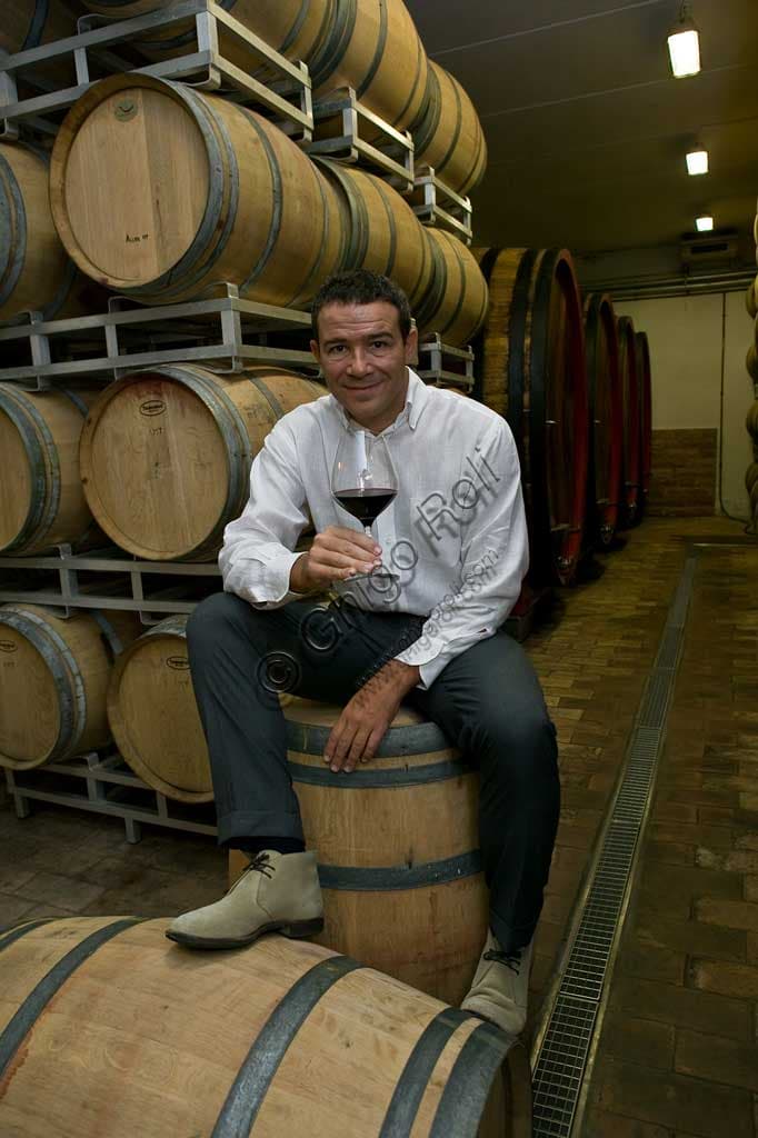 Marco Caprai, owner of the Arnaldo Caprai Winery, inspecting the aging barrels of Sagrantino di Montefalco in a historic Umbrian cellar.