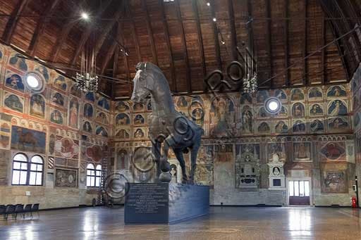 Interior view of the Salone hall in Palazzo della Ragione, Padua, showing the medieval frescoes and the large wooden horse sculpture