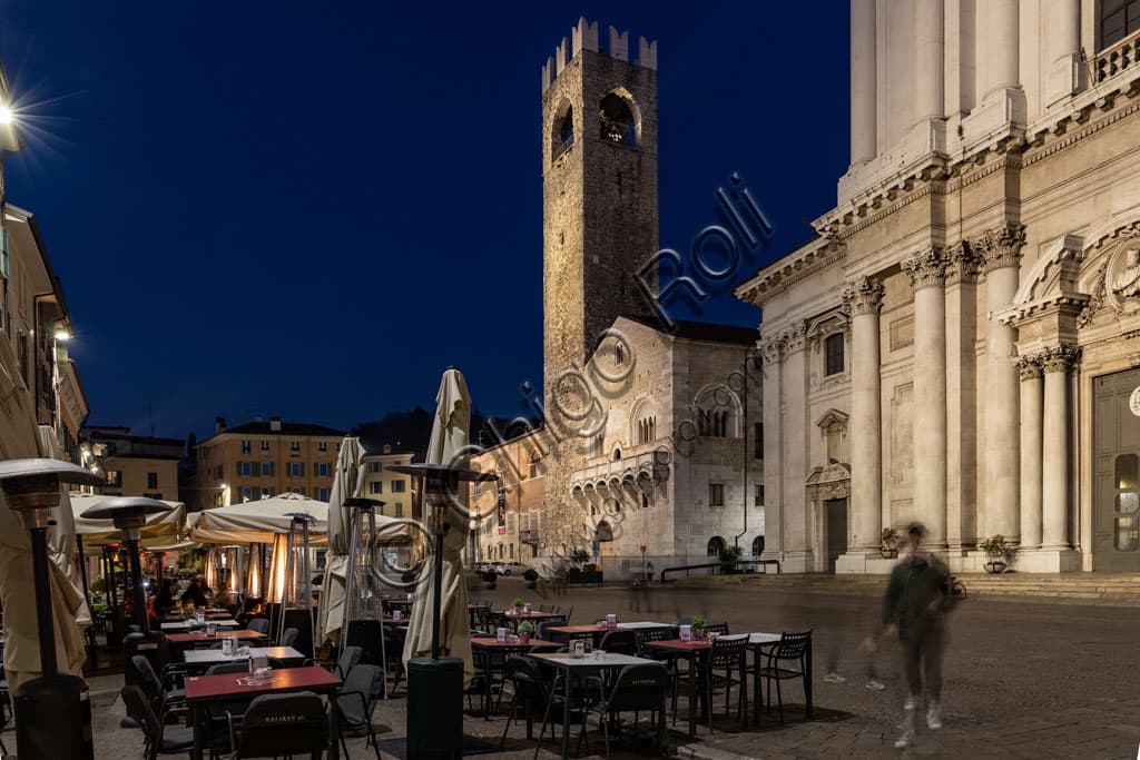 Night view of Paolo VI Square in Brescia with the Broletto and the facade of the New Cathedral