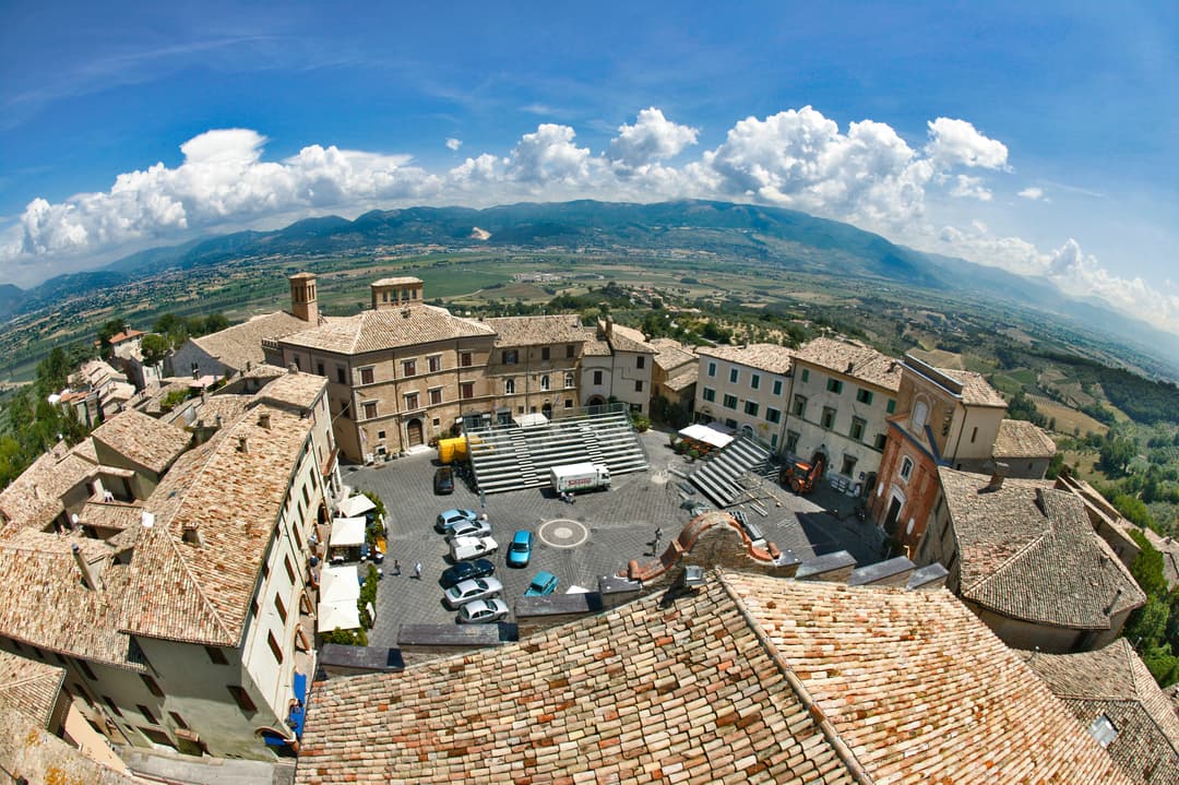 Panoramic view of Montefalco's round town square with the Umbria Valley in the background
