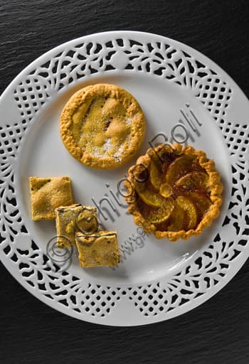 Plate of assorted small sweet and savoury mini pies, served as elegant finger food appetizers