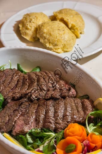 Polenta taragna with beef stew, traditional Valtellina dish served in a rustic pot