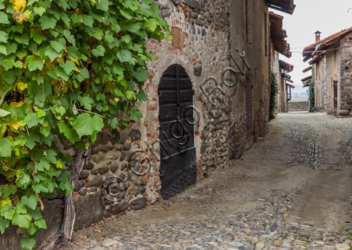 Perspective view of the Rua, the cobbled street of the Ricetto of Candelo, with its characteristic stone and timber buildings