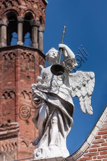 Angel blowing trumpet statue, sculptural detail on the façade of Cremona Duomo, Italy