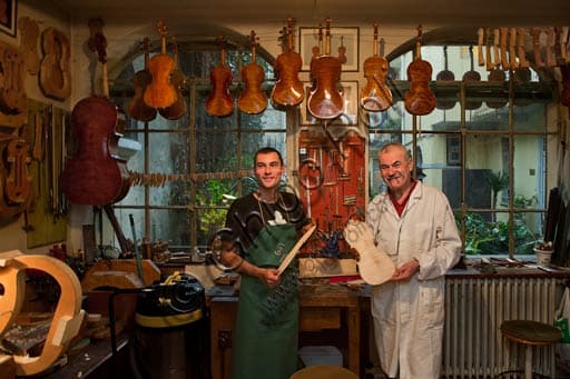 Stefano Conia father and son at work in their violin making workshop in Cremona, Italy, crafting hand-made violins
