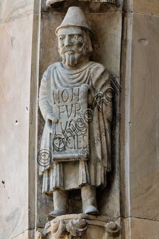 Fidenza, Duomo (Cattedrale di San Donnino), facciata, portale maggiore: dettaglio dell’archivolto con una delle figure di profeti raffiguranti I comandamenti con l’iscrizione: NON / FVR/TVM / FACIES = Non ruberai (Es. 20, 15).Opera di Benedetto Antelami e bottega.