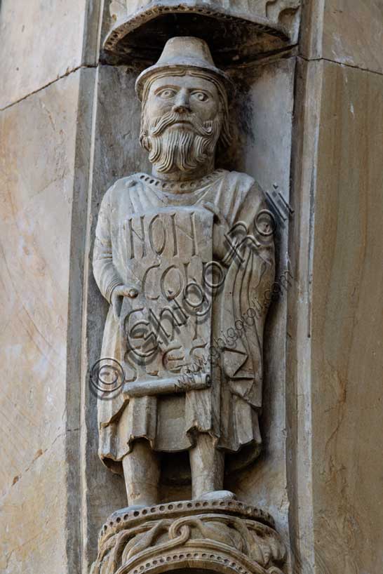 Fidenza, Duomo (Cattedrale di San Donnino), facciata, portale maggiore: dettaglio dell’archivolto con una delle figure di profeti raffiguranti I comandamenti con l’iscrizione: NON / CON/CVPI/SCES = Non desidererai (Es 20, 17).Opera di Benedetto Antelami e bottega.