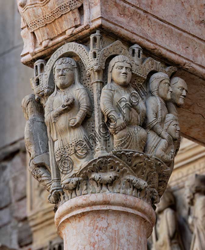 Fidenza, Duomo (Cattedrale di San Donnino), facciata, portale maggiore, protiro: il capitello di sinistra con “Storie di Maria Vergine”. La Madonna è raffigurata nella parte frontale del capitello sotto un edificio sostenuto da due colonne, a figura intera, incinta, ha la rosa in mano; sull’archetto vi è l’iscrizione SCA. MA RIA (Sancta Maria = Santa Maria); a destra, Elisabetta è seduta su uno sgabello con un panno in mano; sull’archetto soprastante vi è l’iscrizione ELIZA.BET (Elisabeth = Elisabetta).Opera di Benedetto Antelami e bottega.