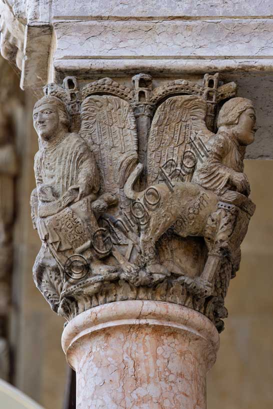 Fidenza, Duomo (Cattedrale di San Donnino), facciata, portale maggiore, protiro: il capitello di destra con “i Quattro Evangelisti”.  A sinistra “S. Matteo”  con piedi umani che porta l’iscrizione: LIBER. / [G]ENE / [R]ACI / [ON]NIS. (Liber generationis (Mt 1,1)= Libro della generazione…)Opera di Benedetto Antelami e bottega.