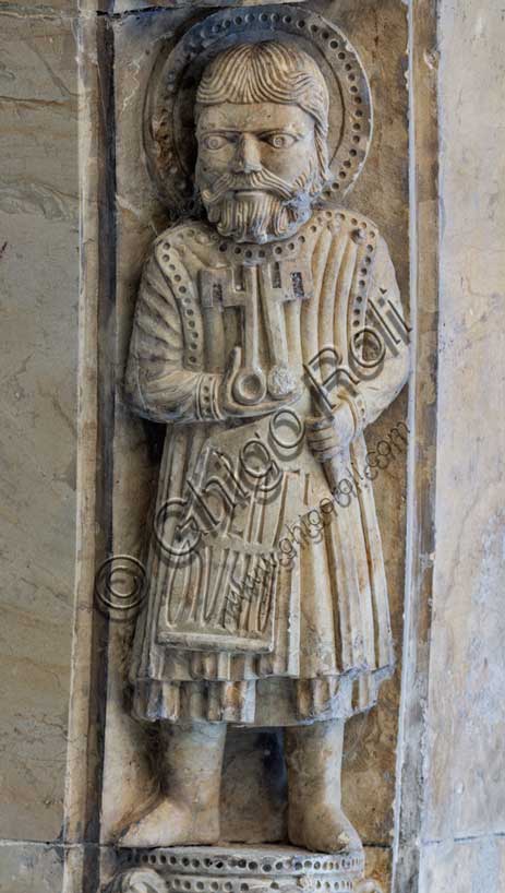 Fidenza, Duomo (Cathedral of San Donnino), facade, main portal: detail of the archivolt with “Allegories of the Beatitudes”. The apostle Peter, with the keys in his hand and the inscription: BEATI / MUNDO = Blessed are the pure (Mt 5, 8).Work by Benedetto Antelami and workshop.