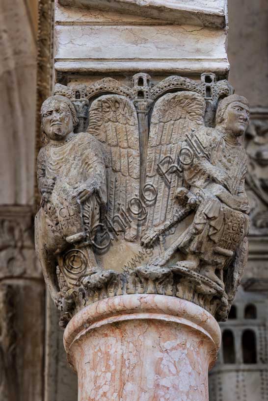 Fidenza, Duomo (Cathedral of San Donnino), facade, main portal, prothyrum:  the right capital with “the Four Evangelists”. On the left “St. Mark”; on the right “St. Matthew”  with human feet bearing the inscription: LIBER. / [G]ENE / [R]ACI / [ON]NIS. (Liber generationis (Mt 1,1) = Book of the generation…).Work by Benedetto Antelami and workshop.