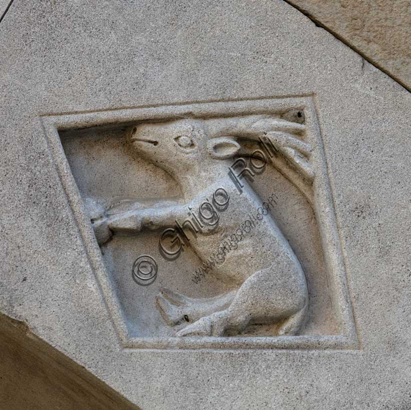 Fidenza, Duomo (Cattedrale di San Donnino), facciata, portale sinistro, protiro, serie di losanghe con allegorie delle virtù teologali e delle virtù cardinali: “la carità”. Opera di Benedetto Antelami e bottega.