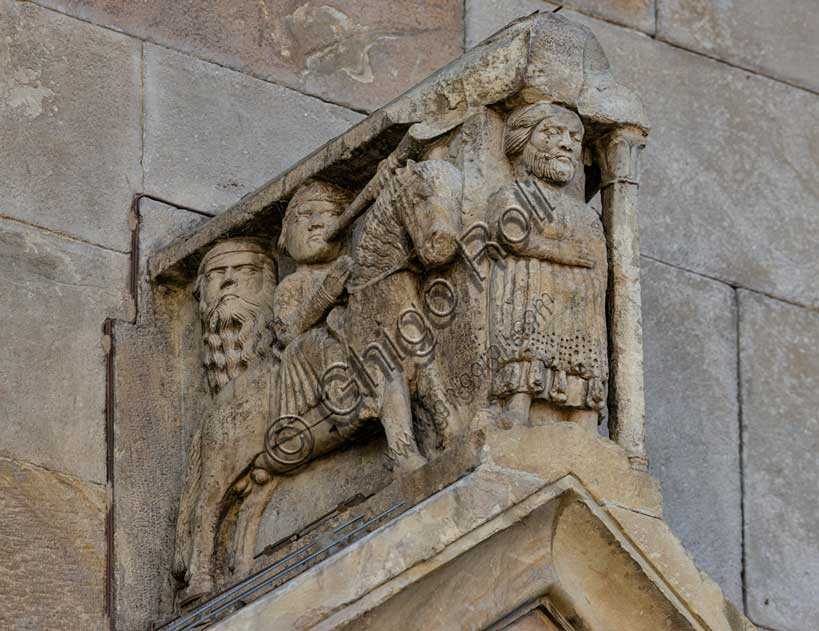 Fidenza, duomo (Cathedral of San Donnino), left portal, tympanum. In the acroterion on the tympanum, a character is depicted, probably Oberto II Pallavicino, a leader placed by Frederick II of Swabia at the helm of the city from 1249 to 1268. At his side there are two trumpet players on horseback.Work by Benedetto Antelami and workshop.