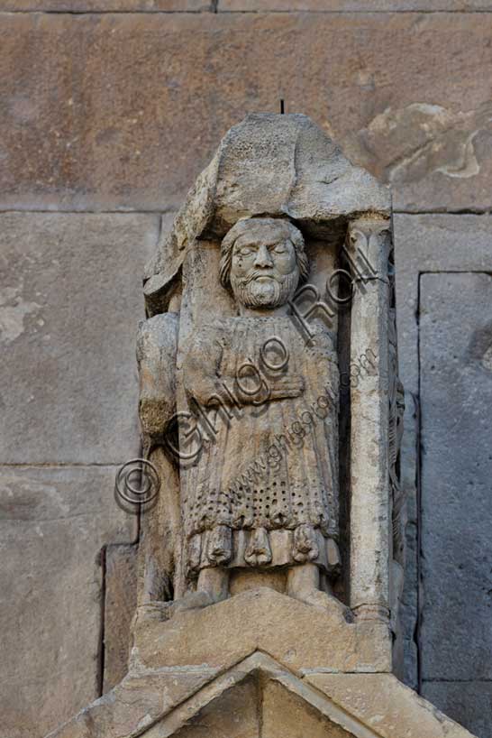 Fidenza, duomo (Cattedrale di San Donnino), portale sinistro, timpano. Nell’acroterio sul timpano, é raffigurato un personaggio, probabilmente Oberto II Pallavicino condottiero posto da Federico II di Svevia alla guida della città dal 1249 al 1268.Opera di Benedetto Antelami e bottega.