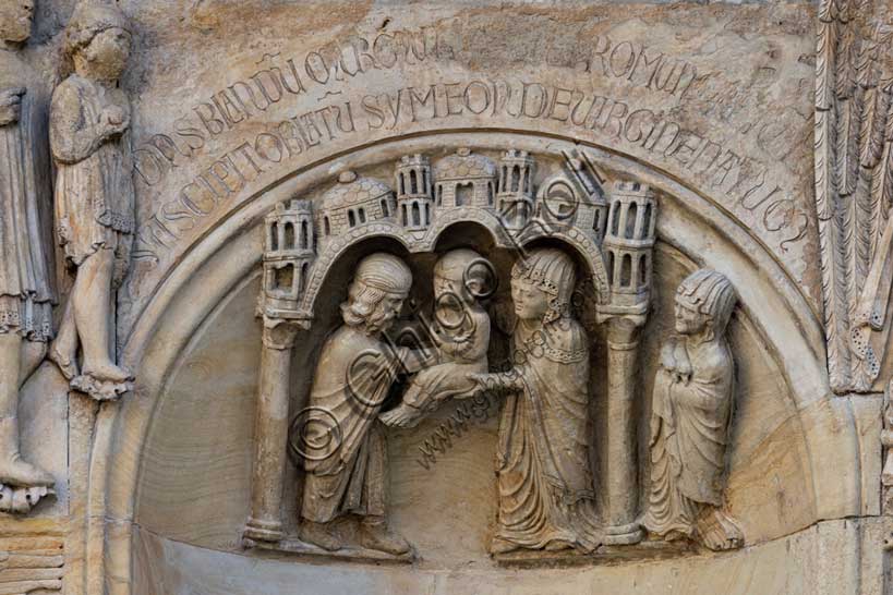 Fidenza, duomo (Cattedrale di San Donnino), sculture tra il portale maggiore e quello di sinistra vicino alla nicchia con il “Re David” di Benedetto Antelami.Particolare della presentazione di Gesù al tempio di Gerusalemme come stabilito dalla legge di Mosè sul primogenito (Lc 2,22-38); è rappresentata sotto un edificio, delimitato da due colonne con capitelli che sostengono un triplice arco sormontato da cupole e torri, ove Maria offre il Bambino Gesù al sacerdote Simeone, il quale ricevendolo, ringrazia Dio. A destra, fuori dall’edificio, una donna ha in mano le due tortore che, come stabilito dalla legge ebraica, erano offerte in sacrifico in quell’occasione.Sopra la nicchia è incisa la seguente iscrizione a lettere capitali: DANSBLANDU MURMU[RDATURP]ROMUN[E]RETUR[TUR] / SUSCIPITOBLATU SYMEONDEVIRGINENATUM (Dans blandum murmur datur pro munere turtur. / Suscipit oblatum Simeon de Virgine natum).