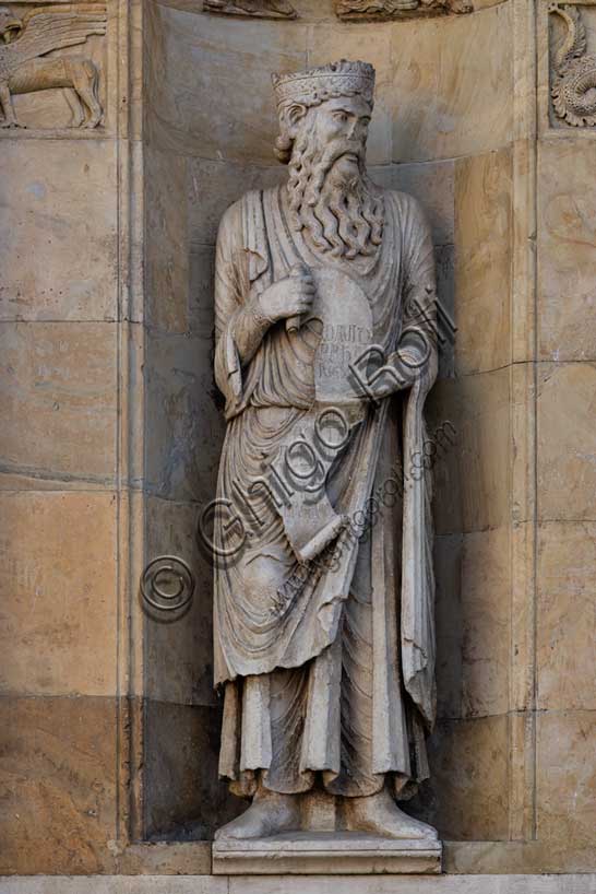 Fidenza, duomo (Cattedrale di San Donnino), sculture tra il portale maggiore e quello di sinistra: la nicchia con il “Re David” di Benedetto Antelami.Il profeta sorregge un cartiglio sul quale si legge la seguente iscrizione a lettere capitali: DAUID / PPHA / REX / HEC / PORTA / DOMINI / IUSTI: / INTRANT PEREAM (David Propheta Rex – Hec porta Domini iusti intrant per eam [Salmo 118 (117),20]).