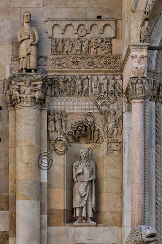 Fidenza, duomo (Cattedrale di San Donnino), sculture tra il portale maggiore e quello di sinistra: la nicchia con il “Re David” di Benedetto Antelami.Il profeta sorregge un cartiglio sul quale si legge la seguente iscrizione a lettere capitali: DAUID / PPHA / REX / HEC / PORTA / DOMINI / IUSTI: / INTRANT PEREAM (David Propheta Rex – Hec porta Domini iusti intrant per eam [Salmo 118 (117),20]).Nella calotta della nicchia è la Presentazione di Gesù al Tempio. Ai lati sono due formelle con le figura di un grifo e di un capricorno; al di sopra di esse si osserva un bassorilievo raffigurante verosimilmente un Angelo che mostra la via per Roma ad una famiglia di pellegrini ricchi. Sopra una fascia ornata con motivi geometrici sono le lastre scolpite che danno inizio alla Storia di San Donnino:Donnino incorona l'imperatore Massimiano in qualità di cubicularius (maestro di camera) e Donnino chiede all'imperatore il permesso di mettersi totalmente al servizio di Cristo.Ancora più in alto, sopra un'elegante fascia con decorazione a tralcio vegetale, troviamo le scene della Adorazione dei Magi e del Sogno di San Giuseppe che continuano idealmente il racconto del testo evangelico iniziato nella torre sinistra.A sinistra, colonna con capitello con la scena di Daniele nella fossa dei leoni e statua di Simone Apostolo che indica la strada per Roma.