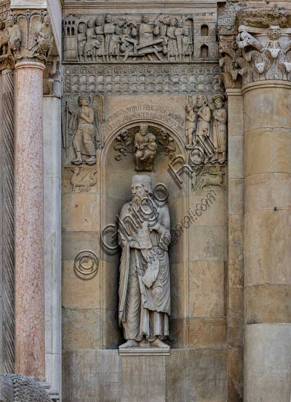 Fidenza, duomo (Cattedrale di San Donnino):“Il Profeta Ezechiele” di Benedetto Antelami.Il profeta sorregge un cartiglio che rimanda al significato della chiesa come "Porta del Cielo"; vi si legge: Ezechiel Propheta; vidi portam in domo Domini clausam (Ezechiele Profeta; ho visto chiusa la porta nella casa del Signore). Nella calotta della nicchia è posto un bassorilievo raffigurante una Madonna col Bambino circondata da racemi di fiori e di frutta sormontata da una scritta che ne spiega il significato teologico.Ai lati della nicchia, sempre in simmetria con la parte sinistra della facciata, vediamo due formelle rappresentanti un'arpia e un centauro che colpisce un cervo, e, più in alto, la figura di un Angelo intento verosimilmente ad indicare ad una famiglia di pellegrini poveri la strada della Via Francigena.Sopra una fascia ornata con motivi geometrici é il bassorilievo del “Miracolo della donna gravida”.