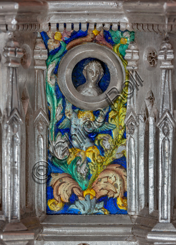 Florence, Museum of the Opera del Duomo (Museum of Florence Cathedral of Santa Maria del Fiore): “the silver altar of St. John's Treasure” (1367 - 1483), by florentine masters.Front of the dossal: detail with enamel floral motifs, putto holding the clypeus with head.