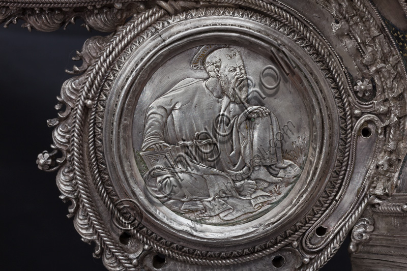 Firenze, Museo dell'Opera del Duomo (Santa Maria del Fiore): “La croce del tesoro di S. Giovanni: il recto”. Splendido esempio di oreficeria rinascimentale, scolpita in lamina d’argento, cesellata e smaltata da Betto di Francesco Betti, Antonio del Pollaiolo e Miliano di Domenico Dei tra il 1457 e il 1459 circa. Venne commissionata a completamento dell’altare d’argento. La Croce-ostensorio è composta da tre parti principali distinte: il Crocifisso, il fusto e la base. Particolare della parte centrale con medaglione che raffigura un santo. 