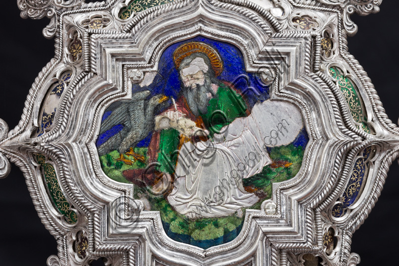 Firenze, Museo dell'Opera del Duomo (Santa Maria del Fiore): “La croce del tesoro di S. Giovanni: il verso”. Particolare con “S. Giovanni Evangelista e l’aquila”.La Croce è uno splendido esempio di oreficeria rinascimentale, scolpita in lamina d’argento, cesellata e smaltata da Betto di Francesco Betti, Antonio del Pollaiolo e Miliano di Domenico Dei tra il 1457 e il 1459 circa. Venne commissionata a completamento dell’altare d’argento. La Croce-ostensorio è composta da tre parti principali distinte: il Crocifisso, il fusto e la base. 