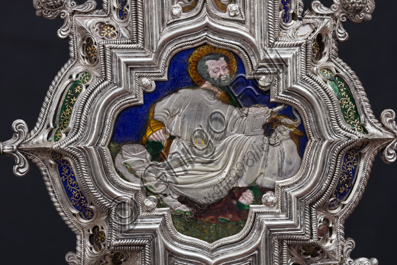 Firenze, Museo dell'Opera del Duomo (Santa Maria del Fiore): “La croce del tesoro di S. Giovanni: il verso”. Particolare con “S. Luca Evangelista e il bue”.La Croce è uno splendido esempio di oreficeria rinascimentale, scolpita in lamina d’argento, cesellata e smaltata da Betto di Francesco Betti, Antonio del Pollaiolo e Miliano di Domenico Dei tra il 1457 e il 1459 circa. Venne commissionata a completamento dell’altare d’argento. La Croce-ostensorio è composta da tre parti principali distinte: il Crocifisso, il fusto e la base. 