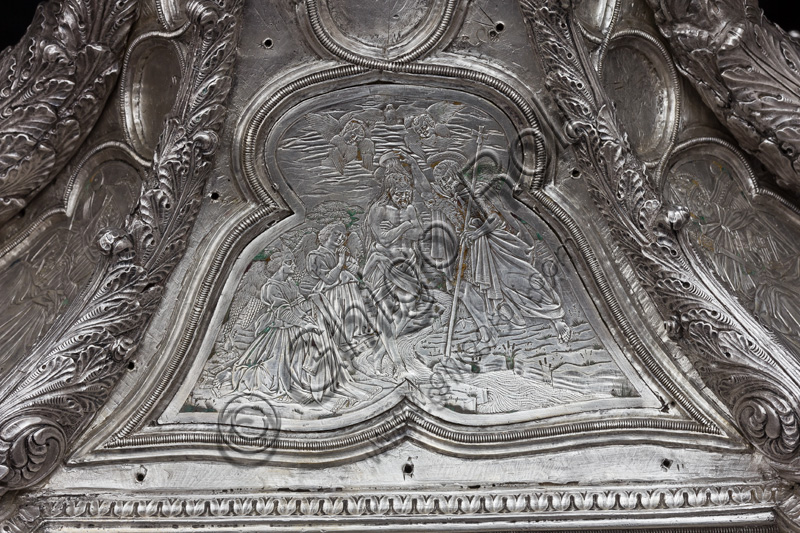 Firenze, Museo dell'Opera del Duomo (Santa Maria del Fiore): “La croce del tesoro di S. Giovanni: il recto”. Splendido esempio di oreficeria rinascimentale, scolpita in lamina d’argento, cesellata e smaltata da Betto di Francesco Betti, Antonio del Pollaiolo e Miliano di Domenico Dei tra il 1457 e il 1459 circa. Venne commissionata a completamento dell’altare d’argento. La Croce-ostensorio è composta da tre parti principali distinte: il Crocifisso, il fusto e la base. Particolare del basamento raffigurazione del “Battesimo di Cristo”.