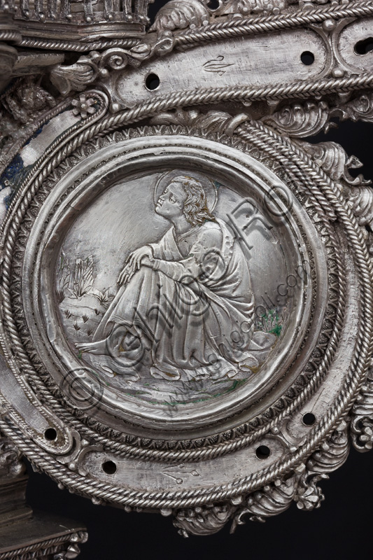 Firenze, Museo dell'Opera del Duomo (Santa Maria del Fiore): “La croce del tesoro di S. Giovanni: il recto”. Splendido esempio di oreficeria rinascimentale, scolpita in lamina d’argento, cesellata e smaltata da Betto di Francesco Betti, Antonio del Pollaiolo e Miliano di Domenico Dei tra il 1457 e il 1459 circa. Venne commissionata a completamento dell’altare d’argento. La Croce-ostensorio è composta da tre parti principali distinte: il Crocifisso, il fusto e la base. Particolare della parte centrale con medaglione che raffigura un santo. 