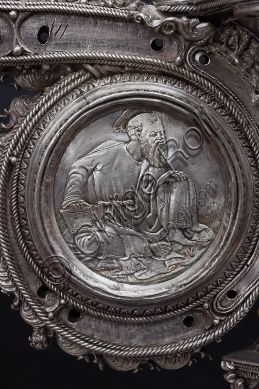 Firenze, Museo dell'Opera del Duomo (Santa Maria del Fiore): “La croce del tesoro di S. Giovanni: il recto”. Splendido esempio di oreficeria rinascimentale, scolpita in lamina d’argento, cesellata e smaltata da Betto di Francesco Betti, Antonio del Pollaiolo e Miliano di Domenico Dei tra il 1457 e il 1459 circa. Venne commissionata a completamento dell’altare d’argento. La Croce-ostensorio è composta da tre parti principali distinte: il Crocifisso, il fusto e la base. Particolare della parte centrale con medaglione che raffigura un santo. 