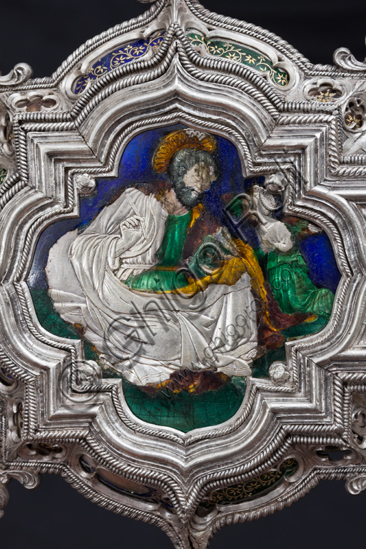 Florence, Museum of the Opera del Duomo (Museum of Florence Cathedral of Santa Maria del Fiore): “The Cross of the Treasure of St. John: the verso.”Detail of “St. Matthew the Evangelist”.The Cross  is a splendid example of Renaissance jewelery, sculpted in silver foil, chiseled and enameled by Betto di Francesco Betti, Antonio del Pollaiolo and Miliano di Domenico Dei between 1457 and 1459 approximately. It was commissioned to complete the silver altar. The Cross-monstrance is made up of three distinct main parts: the Crucifix, the stem and the base. 