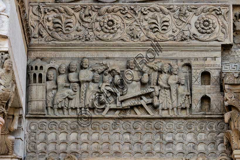 Fidenza, Duomo (Cattedrale di S. Donnino), Facciata: bassorilievo con Storie di San Donnino, "Il miracolo della donna gravida", che racconta con drammaticità l'episodio del crollo di un ponte eccessivamente affollato e il salvataggio della donna incinta per intervento del Santo. Benedetto Antelami e bottega.