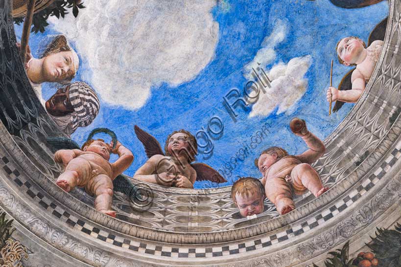 Palazzo Ducale: volta della  “Camera degli Sposi o Camera Picta”, che è una stanza collocata nel torrione nord-est del Castello di San Giorgio di Mantova. È celebre per il ciclo di affreschi che ricopre le sue pareti, capolavoro di Andrea Mantegna, realizzato tra il 1465 e il 1474. Particolare dell’ oculo della volta dove si vede una balaustra dalla quale si sporgono una dama di corte, accompagnata dalla serva di colore, e alcuni putti.